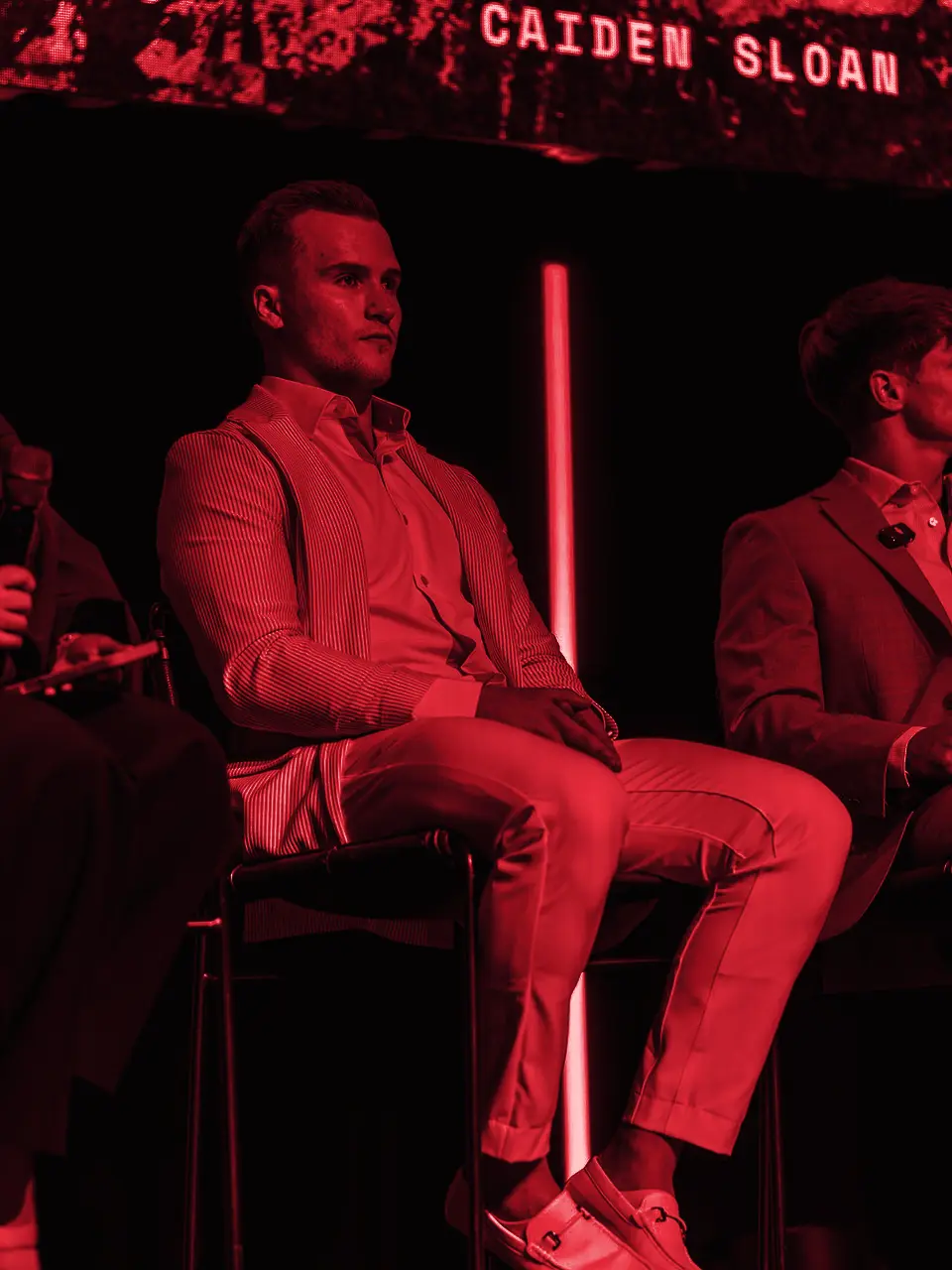Caiden Sloan seated on stage under his name on the screen